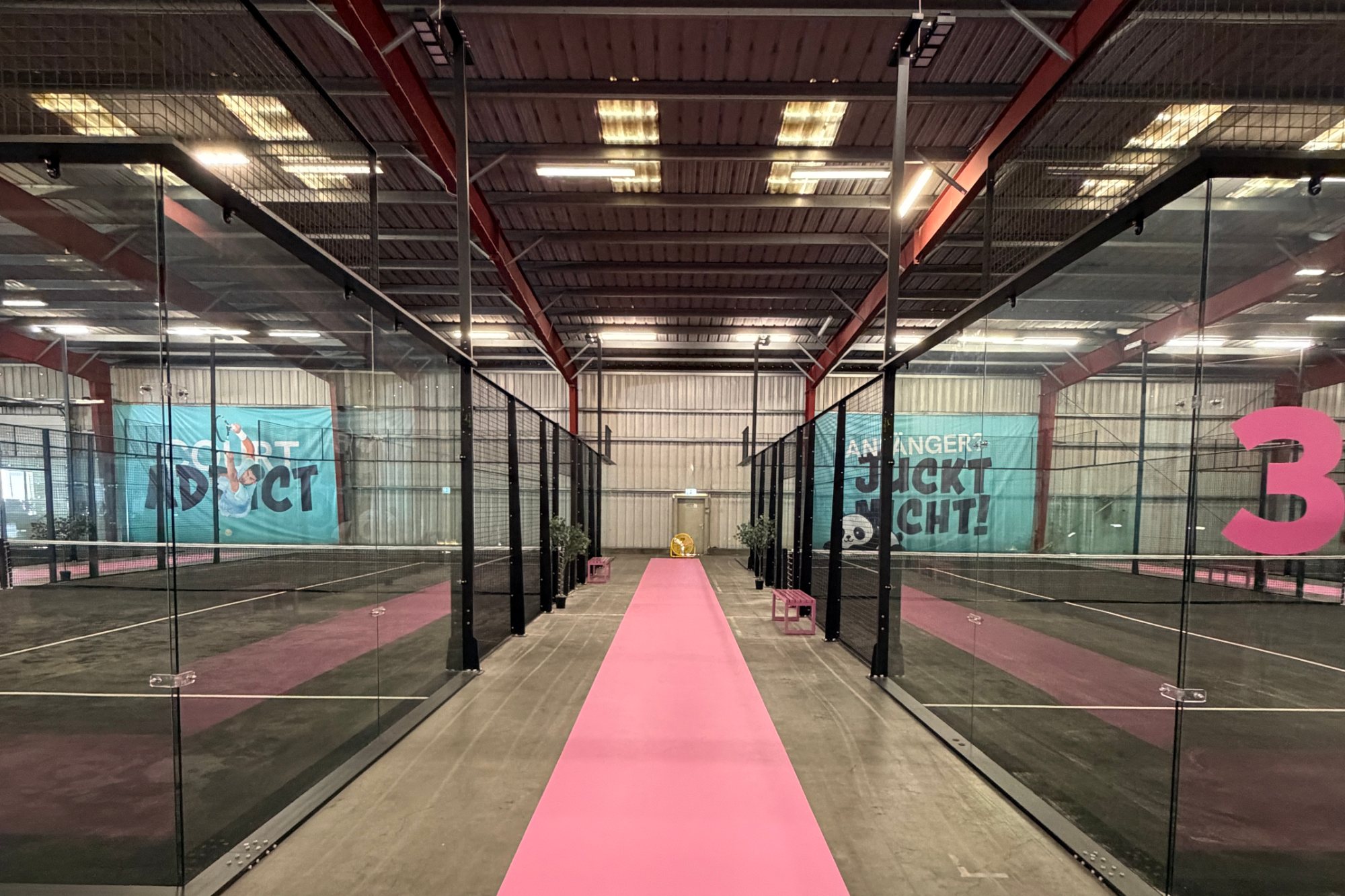 Ultrapanoramatické padelové kurty Go4Padel v hale s více kurty — pohled mezi dvěma kurty